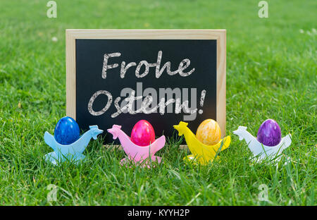 Eastercard with chalkboard and colorful Easter eggs with german text: Happy Easter Stock Photo
