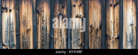 Vintage faded wall from planks with knots. Brown striped panoramic texture from wood as background. Stock Photo