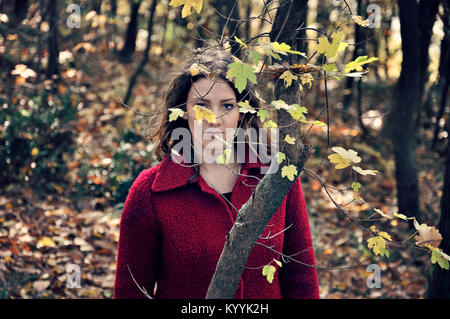 Young woman standing alone in forest Stock Photo