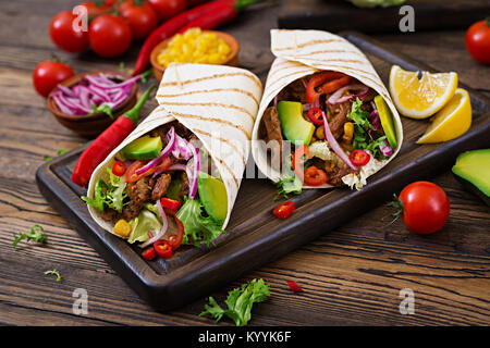 Mexican tacos with beef in tomato sauce and avocado salsa Stock Photo