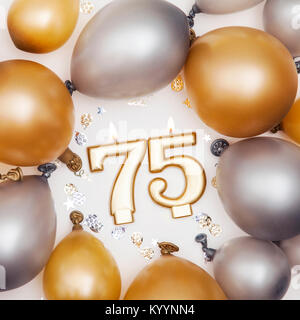 Birthday celebration number 75 candle with gold and silver balloons Stock Photo