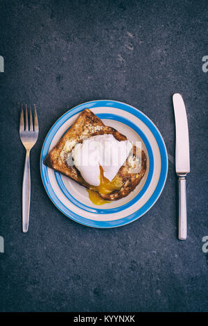Poached egg on toast on a slate background from above. Vintage filter applied Stock Photo