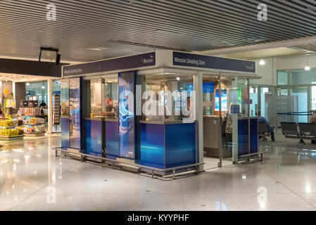 ATHENS, GREECE - May 16, 2017: Tourists and travelers smoke cigarettes in a smoking zone. Athens Airport Terminal, Greece. Stock Photo