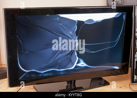 Broken flat screen television on a workshop table Stock Photo