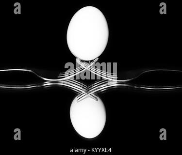Eggs on two forks mirrored black and white Stock Photo