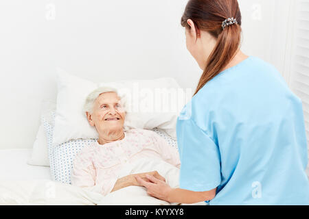 Old woman in hospice or nursing home is being comforted by a nurse Stock Photo