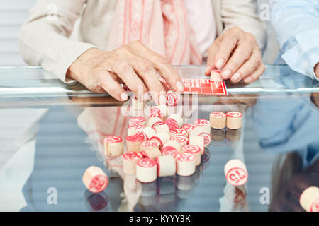 Hands of seniors playing bingo as a memory training in the retirement home Stock Photo