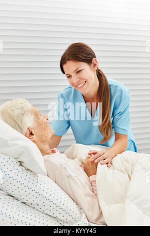Nurse cares for a sick elderly woman in the hospice or at home Stock Photo