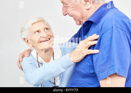 Amorous senior couple smiling happily at home or in retirement home Stock Photo