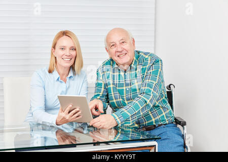 Family with Senior and Young Woman as a Daughter Using a Tablet Computer Stock Photo