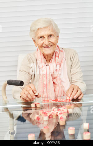 Old senior has fun playing bingo in the afternoon at the retirement home Stock Photo