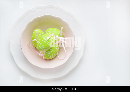 Easter eggs in a pink and white plate on white background. Stock Photo