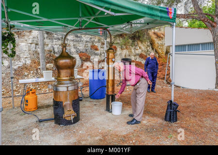 Arsos Village, Cyprus - October 8, 2017: Man testing Zivania from a working still at a village festival. Stock Photo