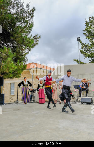 Arsos Village, Cyprus - October 8, 2017: Two men dressed in traditional clothing performing syrtos folk dance at a festival. Stock Photo