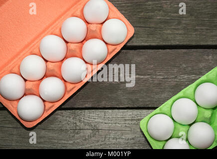 Carton of organic white eggs on wooden background. View from above. Stock Photo