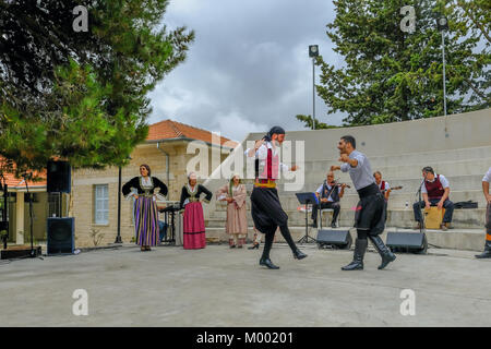 Arsos Village, Cyprus - October 8, 2017: Two men dressed in traditional clothing performing syrtos folk dance at a festival. Stock Photo