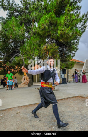 Arsos Village, Cyprus - October 8, 2017: Man dressed in traditional clothing performing folk dance, thrapani, holdng a scythe, at a festival. Stock Photo