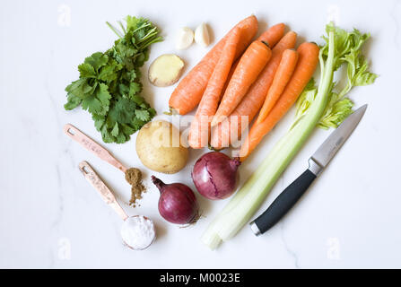 Ingredients for carrot, coriander and ginger soup on a marble background. Stock Photo