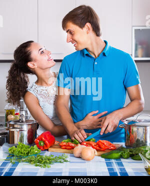 Young couple cooking dish with vegetable in domestic kitchen Stock Photo