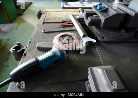 A grinder and other working tools on a factory table Stock Photo