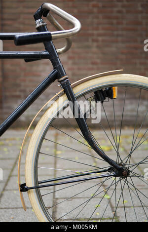 Detail of the front of a vintage Path Racer bike with a double frame in front of a brick wall. Stock Photo