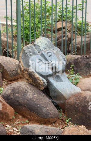 Grey carved stone art statue of two heads kissing, Mosi-Oa-Tunya, Victoria Falls, Zimbabwe. Stock Photo