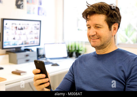 Man with mobile in the officine Stock Photo