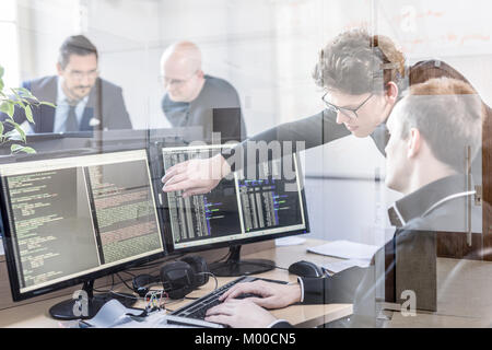 Startup business problem solving. Software developers working on desktop computer. Stock Photo