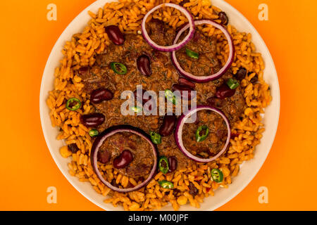 Mexican Style Chilli Con Carne With Rice and Onions Against An Orange Background Stock Photo