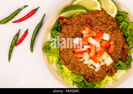 Spicy Mexican Style Beef Taco Meat and Salad With Fresh Limes Isolated Against A White Background Stock Photo