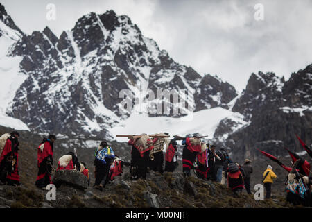 Cusco, Peru. 29th Dec, 2017. Members of the Paucartambo nation, ascend to Ausangate Mountain, at 6362m, carrying their cross to be blessed by the Lord of Qoyllur Riti.The pilgrimage includes processions with crosses that climb to the snowy summit of the mountain and then descend the next day.Quyllur Rit'i or Star Snow Festival is a spiritual and religious festival held Annually at the Sinakara Valley in the Cusco Region of Peru. Groups of Quero indigenous people climb Ausangate Mountain, at 6362m, in search of the Snow Star Which is reputedly buried Within the mountain.According to the Stock Photo