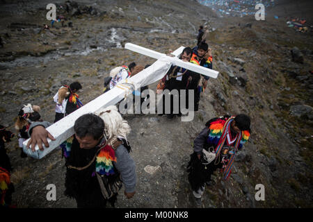 Cusco, Peru. 29th Dec, 2017. Members of the Urubamba nation, ascend to Ausangate Mountain, at 6362m, carrying their cross to be blessed by the Lord of Qoyllur Riti.The pilgrimage includes processions with crosses that climb to the snowy summit of the mountain and then descend the next day.Quyllur Rit'i or Star Snow Festival is a spiritual and religious festival held Annually at the Sinakara Valley in the Cusco Region of Peru. Groups of Quero indigenous people climb Ausangate Mountain, at 6362m, in search of the Snow Star Which is reputedly buried Within the mountain.According to the ch Stock Photo