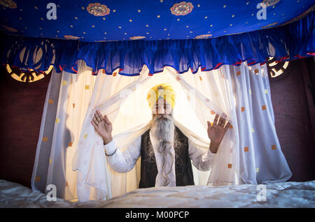 Frankfurt am Main, Germany. 07th Jan, 2018. Sikh priest Mammohan Singh stands with his arms spread in front of the 'Guru Granth Sahib', the holy book of the Sikh at the Gurdwara Sikh Temple in Frankfurt am Main, Germany, 07 January 2018. The book lies underneath a blue fabric canopy in an especially protected room. The Sikh community in Frankfurt is the largest in Germany and in Europe. On weekends, up to 2000 people meet for prayers. Credit: Boris Roessler/dpa/Alamy Live News Stock Photo