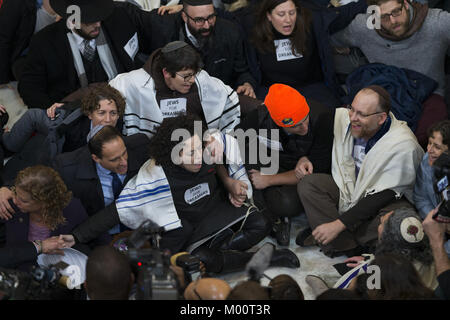 Washington, District Of Columbia, USA. 17th Jan, 2018. Jewish activists, joined by Representative DEBBIE WASSERMAN SCHULTZ, Democrat of Florida, left, participate in an act of civil disobedience in support of DACA legislation and in support of dreamers in the Russell Senate Office Building. Dozens of rabbis and protestors from various Jewish groups were arrested Wednesday by Capitol Hill police officers. Credit: Alex Edelman/ZUMA Wire/Alamy Live News Stock Photo