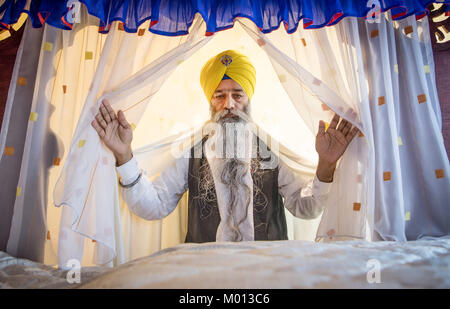 Frankfurt am Main, Germany. 7th Jan, 2018. Sikh priest Mammohan Singh stands in front of the protected holy book 'Guru Granth Sahib' with his arms spread wide at the Gurdwara Sikh temple in Frankfurt am Main, Germany, 7 January 2018. The book is placed beneath a blue cloth in a secured room. The Sikh community in Hesse is the largest in Europe - Up to 2000 people can come together for weekend prayers. Credit: Boris Roessler/dpa/Alamy Live News Stock Photo