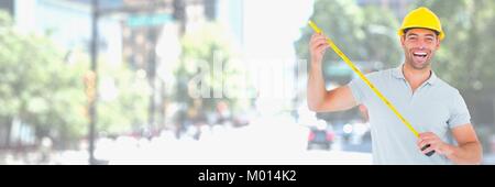 Construction Worker on building site holding measuring tape Stock Photo