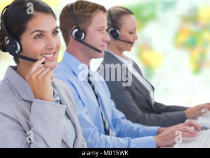 Travel agents wearing headsets in front of world map Stock Photo
