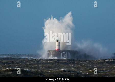 Breaking wave over Newhaven Lighthouse in East Sussex and rough sea. Stock Photo