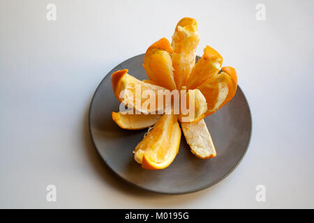Fresh orange slices in flower shaped form isolated on grey concrete plate Stock Photo