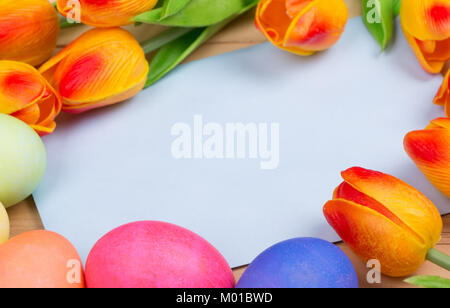 Blank envelope surrounded with colored Easter eggs and tulips Stock Photo