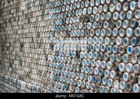 Bottle recycling: plastic bottles which have been set in concrete to form a bottle wall Stock Photo