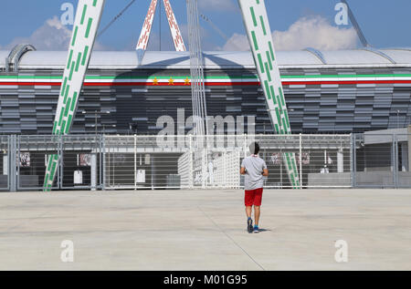 Torino, Italy - August 26, 2015: young fan in front of the huge sports facility called Juventus Stadium Stock Photo