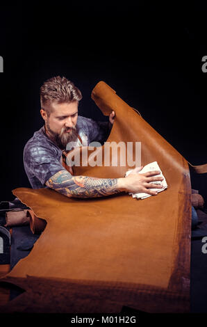 Worker of leather creates quality product of leather in his leather studio./Leather Skinner creates a new leatherwork. Stock Photo