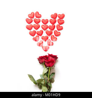Red hearts as shape and bouquet of red roses on white. Top view. Valentine's card concept. Square image. Stock Photo