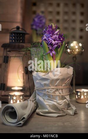 Delicate purple hyacinth on vintage kitchen lit with candles Stock Photo