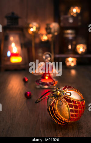Christmas toys and candles on vintage kitchen. Shallow DOF, focus on front parts of the bauble in front Stock Photo