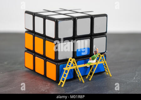 miniature people worker painting cube blue orange Stock Photo