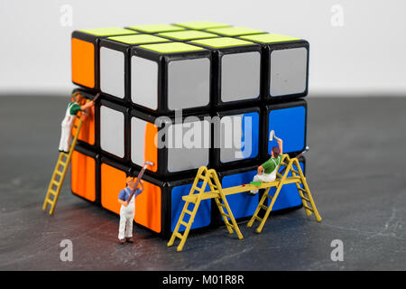 miniature people worker painting cube blue orange Stock Photo