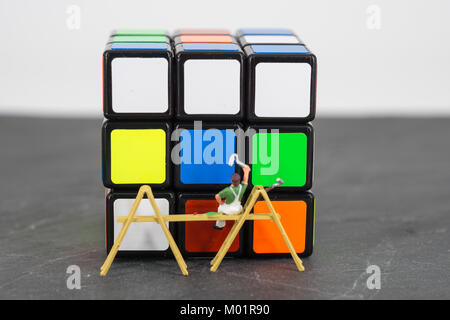 miniature people worker painting cube blue orange Stock Photo