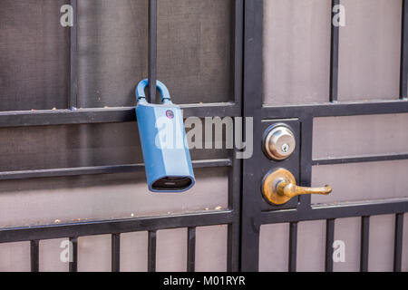 Real Estate lock box on a gate to a house. This way agents have access to a key and can show the house to clients. Stock Photo